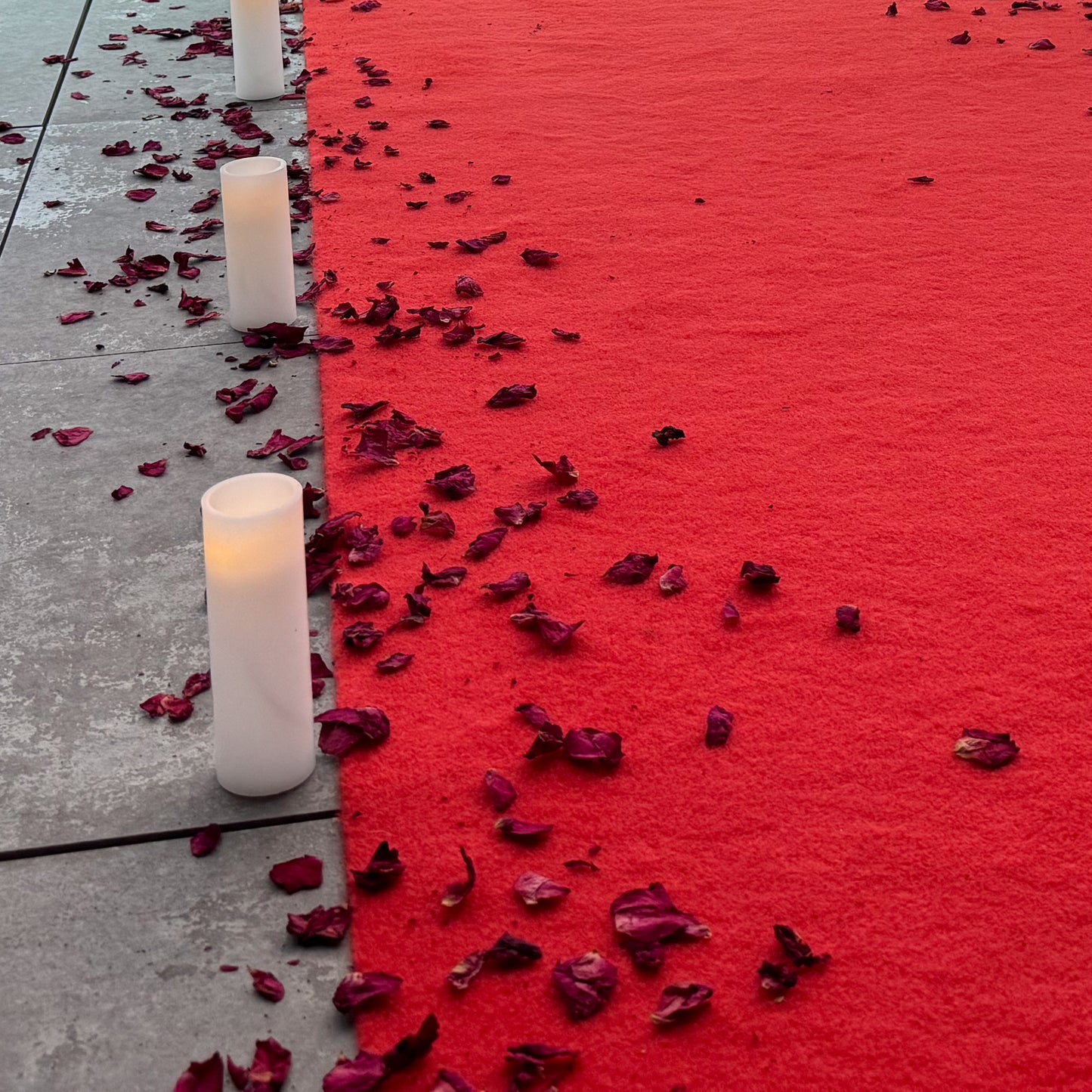 Close up of red carpet with candles and rose petals for romantic proposal in Melbourne