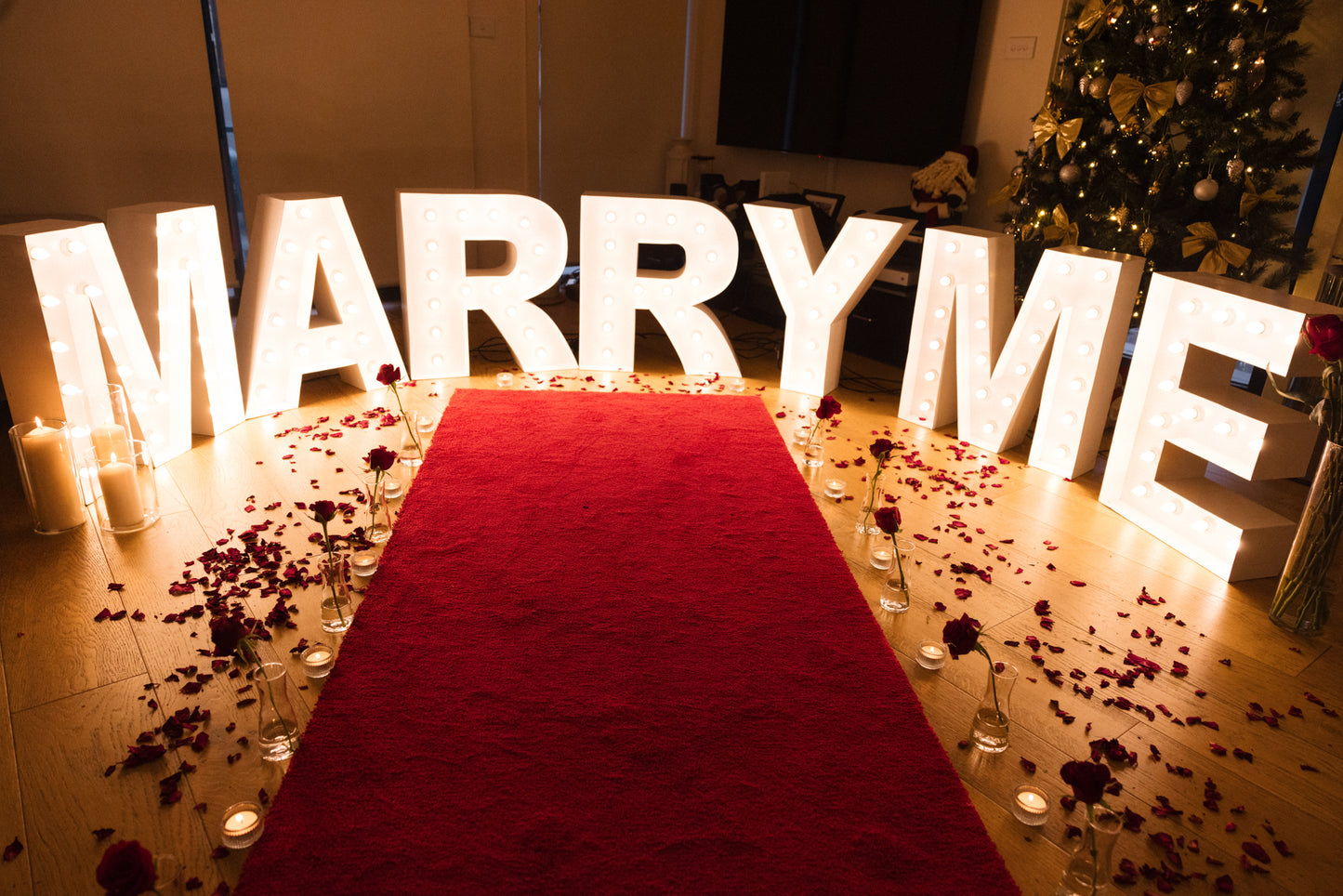 Red carpet hire Melbourne with marry me lights, candles and rose petals for proposal