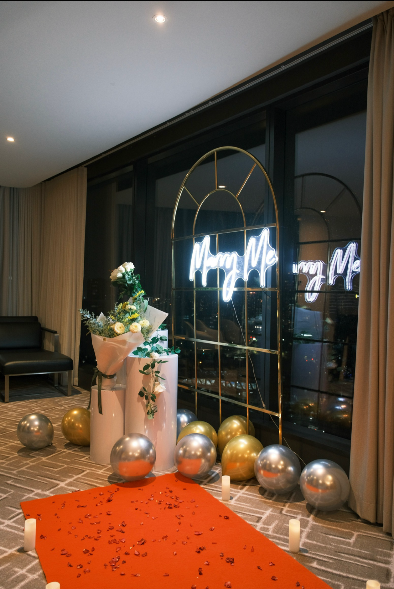Decorative setup with balloons and a sign in a modern interior setting