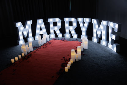 Red carpet hire Melbourne with marry me marquee lights and candles for proposal